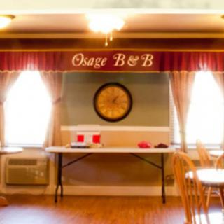 Interior of a bed and breakfast dining area with tables and a clock on the wall.