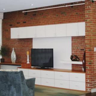 A modern living room featuring a sleek TV unit against a stylish brick wall.