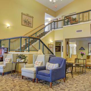 A spacious lobby with comfortable seating and a grand staircase.