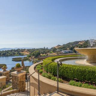 A scenic view of a coastal terrace featuring a fountain overlooking the ocean.