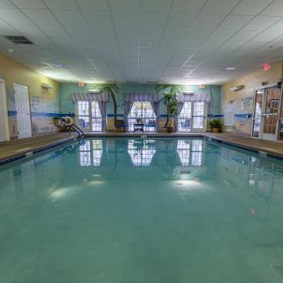 An inviting indoor swimming pool area with natural light and surrounding decor.