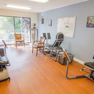 A physical therapy room equipped with exercise machines and seating.