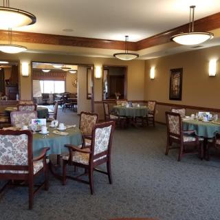 A cozy dining area with neatly arranged tables and upholstered chairs.