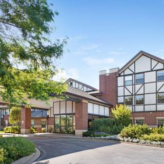 A modern hotel building with landscaped surroundings and a parking area.