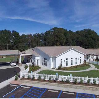 A modern community center surrounded by greenery and landscaped areas.