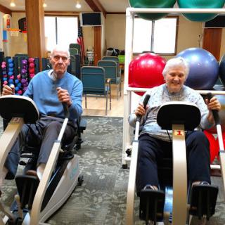 Seniors engaging in fitness activities together at a gym.