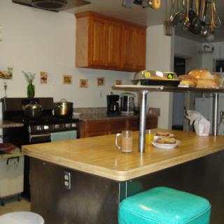 A cozy kitchen featuring a wooden island countertop with food items and modern appliances.