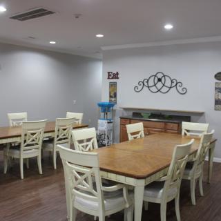 A cozy dining area with wooden tables and white chairs, complemented by modern decor and lighting.