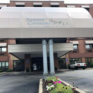 The front entrance of a building with an awning and landscaping.