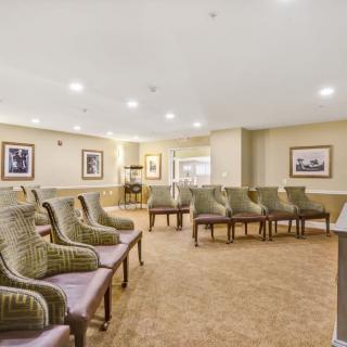 A spacious waiting room with neatly arranged chairs and soft lighting.
