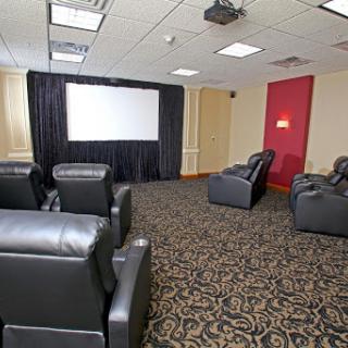 A cozy home theater setup with recliner seating and a large screen for movie nights.