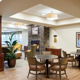 A cozy lounge area features comfortable seating, a fireplace, and warm lighting.