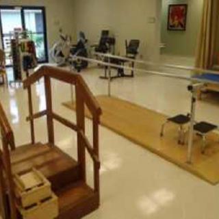 A rehabilitation room equipped with exercise and physical therapy equipment.