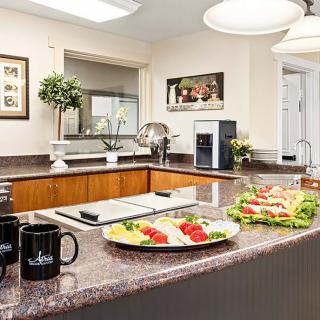 A modern kitchen with a granite countertop, featuring plates of food and stylish decor.