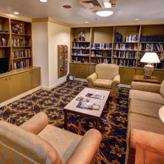 A cozy library reading room with armchairs and bookshelves.