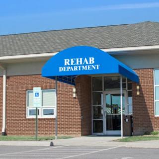 Entrance to a rehabilitation department with a blue awning.
