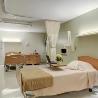 A clean and organized hospital room with beds and medical equipment.
