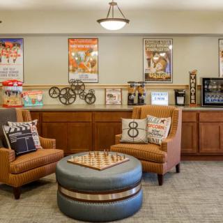 A cozy lounge area with comfortable chairs, movie-themed decorations, and a small refreshment station.
