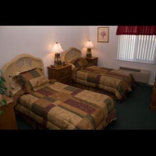 A cozy bedroom with two twin beds, each accompanied by a nightstand and lamp.