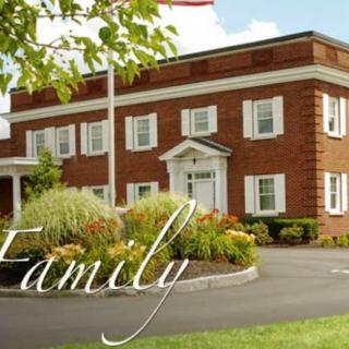 A brick building surrounded by greenery with the word 'Family' displayed over it.