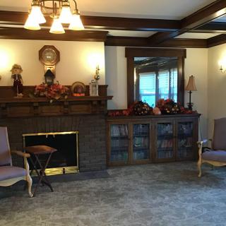 A cozy living room with traditional decor, featuring a fireplace and comfortable seating.