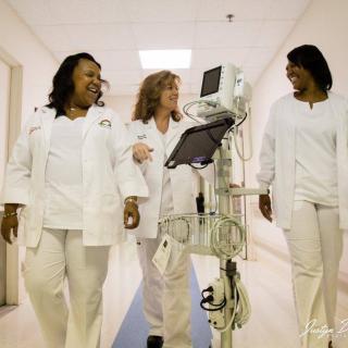 A group of nurses walking together in a hospital hallway.