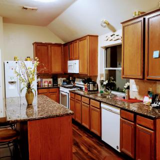 A modern kitchen with wood cabinets and a granite countertop.