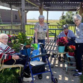 A group of seniors enjoying gardening activities outdoors.