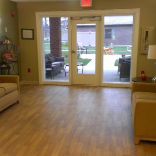 A cozy lounge area with sofas and a large windowed door leading outside.