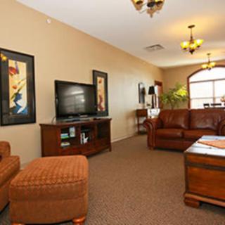 A cozy living room featuring a sofa, television, and decorative artwork.