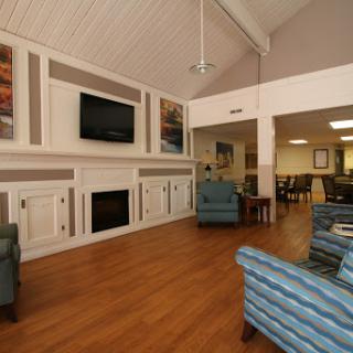 A cozy lounge area featuring comfortable seating, a fireplace, and a television, perfect for relaxation and social gatherings.