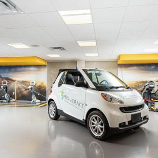 A compact smart car displayed in a modern showroom.