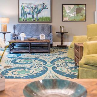 A cozy living room with colorful furniture and artwork.