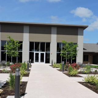 A modern building with a landscaped pathway leading to the entrance.