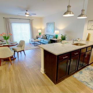 A modern open floor plan with a cozy living room, dining area, and kitchen featuring a central island and stylish decor.