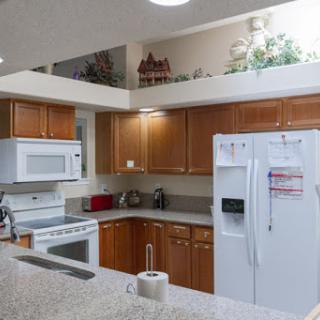 A modern kitchen featuring wooden cabinets and essential appliances.