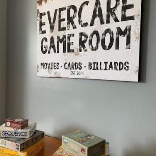 A cozy game room featuring a vintage sign and a selection of board games.