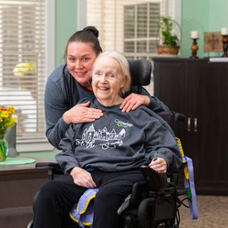 A joyful moment shared between a caregiver and an elderly resident, highlighting the importance of companionship and care.