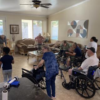 A lively social gathering in a care facility, featuring seniors engaged in conversation and activities.
