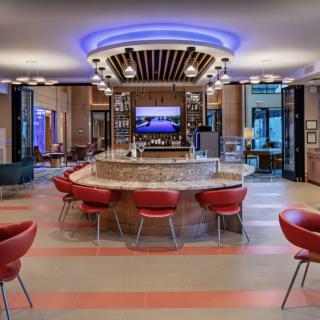 A modern bar with a central counter and red seating.