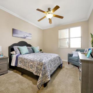 A cozy bedroom with a double bed, bedside tables, and a ceiling fan.