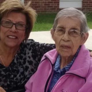 Two women sitting outdoors together.