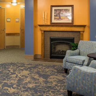 A cozy living room with a fireplace, armchair, and decorative elements.
