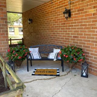 A cozy and inviting porch area adorned with flowers and comfortable seating.