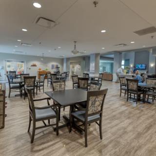 A modern and spacious dining area with neatly arranged tables and chairs, featuring stylish decor and ample lighting.