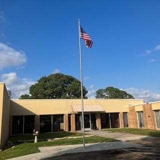 A building featuring an American flag under a clear blue sky.