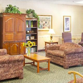 A cozy living room with comfortable seating, a bookshelf, and warm lighting.