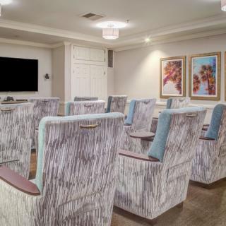 A modern conference room with arranged seating and a large screen, designed for meetings.