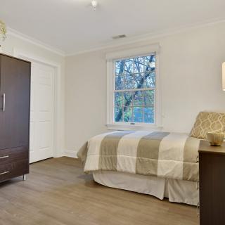A minimalist bedroom with a bed, wardrobe, and window.