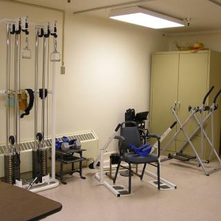 A rehabilitation room equipped with exercise machines and therapy tools.